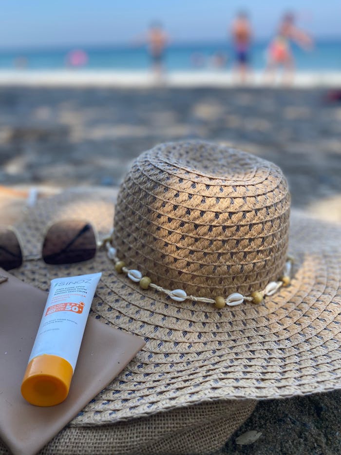 services-01 A straw hat and sunscreen on a sandy beach, perfect for summer vacations.